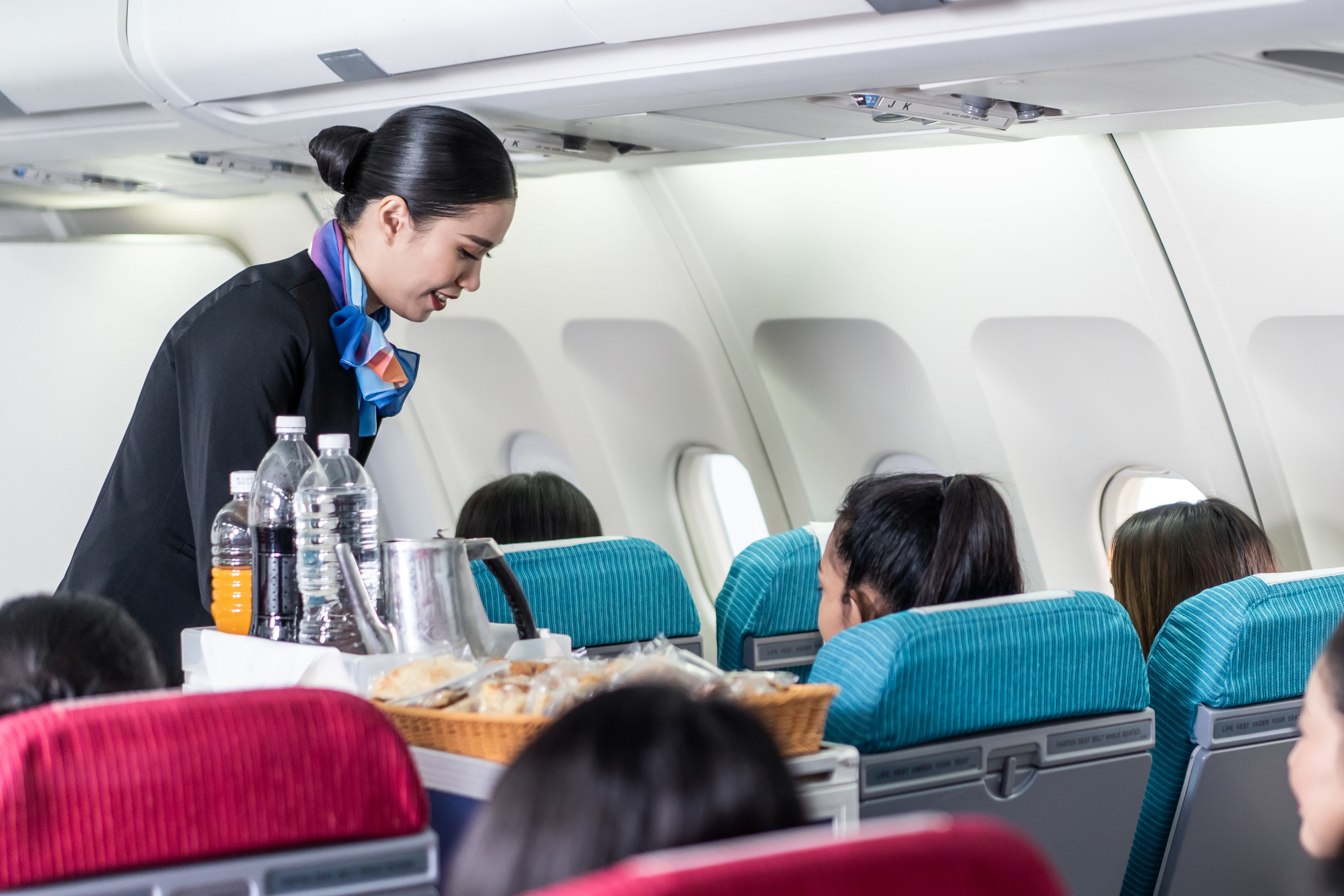 Flight attendant serving passengers on an airplane
